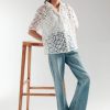 Model wearing white cutwork short sleeve button-down top