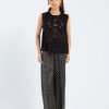 Model wearing jet black sleeveless embroidered kurti with schiffli details